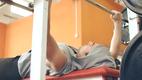  Strong male bodybuilder doing bench press exercise with heavy barbell in gym Stock Footage 72023266