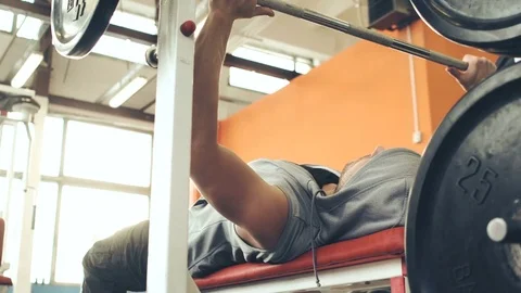  Strong male bodybuilder doing bench press exercise with heavy barbell in gym Stock Footage 72025115