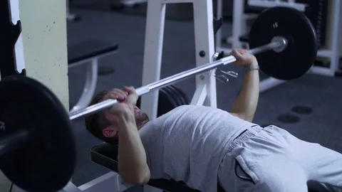 Strong male bodybuilder doing bench press exercise with heavy barbell in gym Stock Footage 81412853