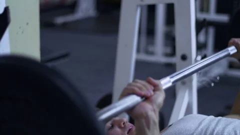 Strong male bodybuilder doing bench press exercise with heavy barbell in gym Stock Footage 81413013