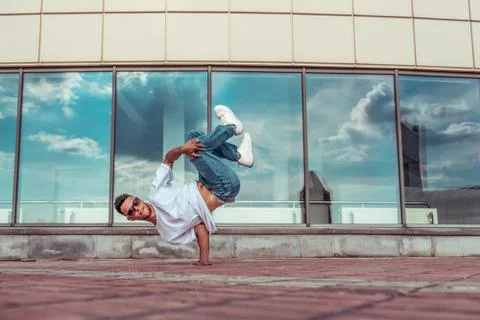 Strong man acrobat dancer, dancing breakdance, summer city, free space for text 스톡 사진