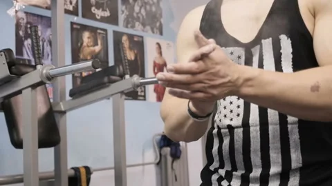 Strong man applying magnesia powder on his palms and going to do training Stock Footage 88601903