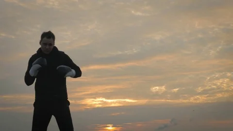 Strong man in a boxing gloves on the rooftop Stock Footage 83282766