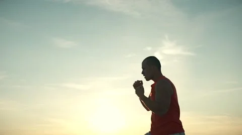 Strong man boxing at sunset at the beach, sky Stock Footage 68990627