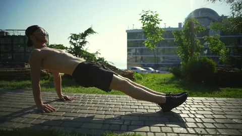 Strong man do reverse plank exercises in sunny green park rapid slow motion Stock Footage 78038220