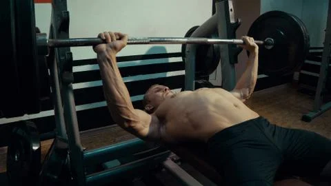 Strong man doing barbell bench press. Stock Photos