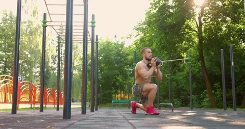 Strong man Doing Exercises Lifting Kettlebell Fitness. Naked torso, summer day Stock Footage 157890165