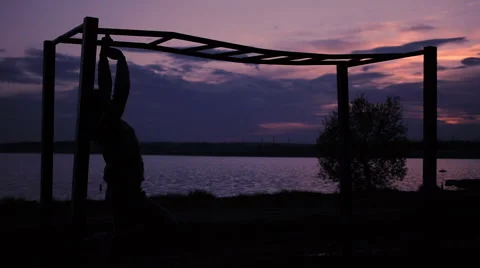 Strong Man doing Pull Ups Outdoor under very Hot Sun in a park Stock Footage 64021917
