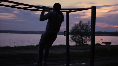 Strong Man doing Pull Ups Outdoor under very Hot Sun in a park Video stock 64022105