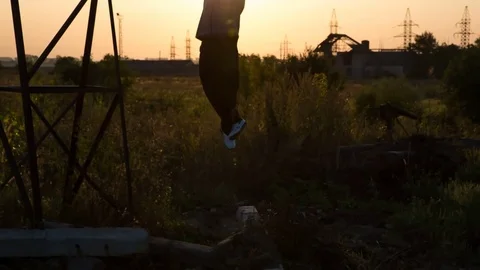 Strong Man doing pull-ups outdoor. Silhouette of an athlete in the park in the Stock Footage 79449688