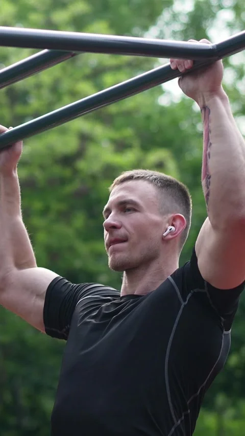Strong man doing pull ups on monkey bars Vertical video Stock Footage 244776845