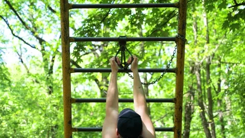 Strong man doing pull ups on narrow bars on outdoor gym Stock Footage 276094519