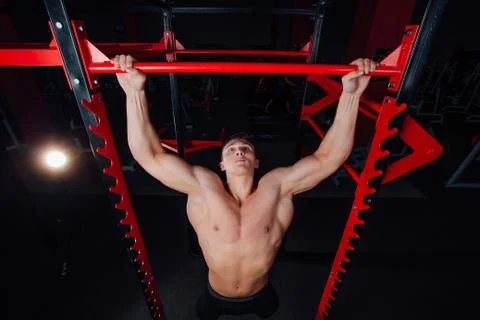 Strong man doing pull ups handsome athlete at gym. big confident muscular Stock Photos