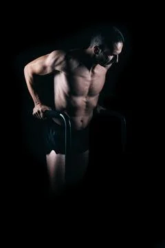 Strong man doing pull-ups with bars. Stock Photos