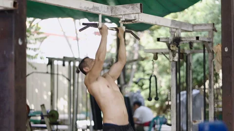 Strong man doing pullups in a park in Thailand Stock Footage 265568861
