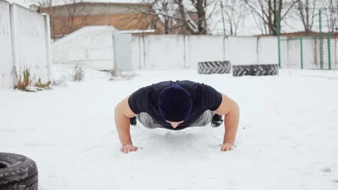 Strong man doing push ups on the snow, crossfit exercise Stock Footage 99934901
