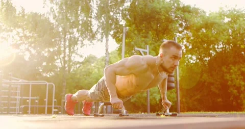 Strong man doing push ups at sports ground in city park.Athlete showing hard and Stock Footage 156978087