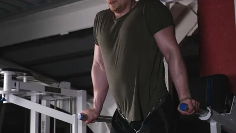 Strong man doing push-ups on the uneven bars 库存影片 170478517