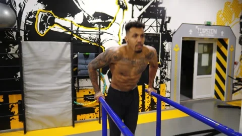 Strong man doing push ups on parallel bars at sport club. Muscular sportsman Stock Footage 311040476