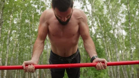 Strong Man Exercising on Horizontal Bar Outdoors 스톡 동영상 330921324