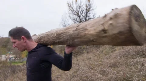 Strong man going downhill with a log on the shoulders (BMCC 2.5K - 2400x1350) Stock Footage 47942414