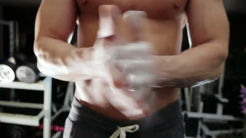 Strong man handles talc hands, slowing down Stock Footage 75807378