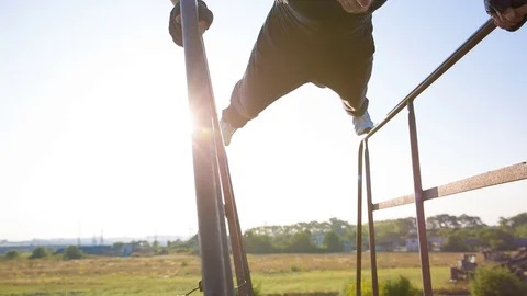 Strong man making triceps fall on parallel bars in the park. Stock Footage 79576494