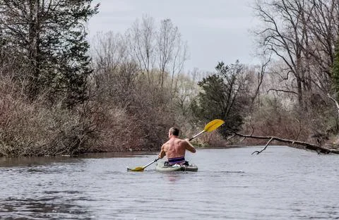Strong man paddling on a river alone Stock Photos