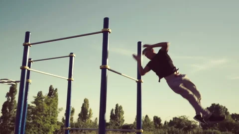 Strong man performing exercises on the uneven bars Stock Footage 90932767