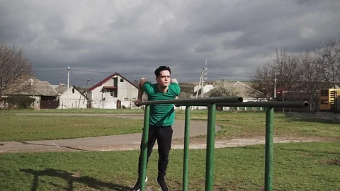 Strong man performing exercises on the uneven bars Stock Footage 106711834