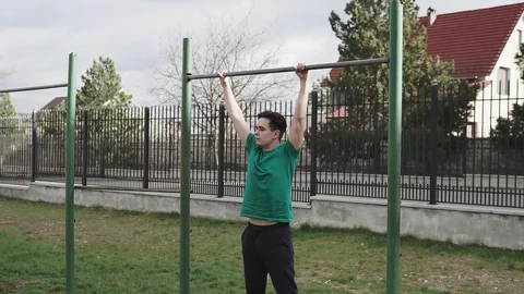 Strong man performing exercises on the uneven bars, sport and healthy lifestyle. Stock Footage 107586201