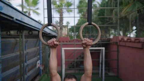 Strong man performing pull ups on gymnastic rings. Slow motion 動画素材 205450661