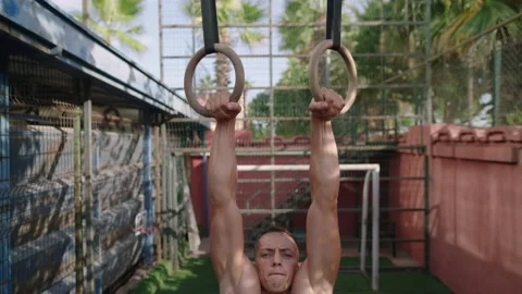 Strong man performing pull ups on gymnastic rings. Slow motion Stock Footage 205850822