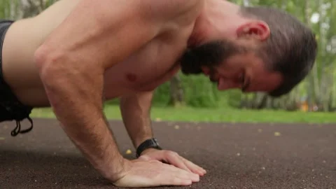 Strong Man Performing Push-Ups in Park Video stock 329599179