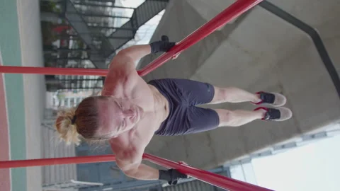Strong Man Performing Upside Down Pull Ups on Parallel Bars Outdoor 스톡 동영상 260048700