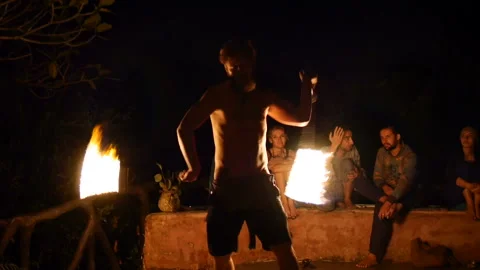 Strong man performs fire dancing show with torches at night Video stock 102488780