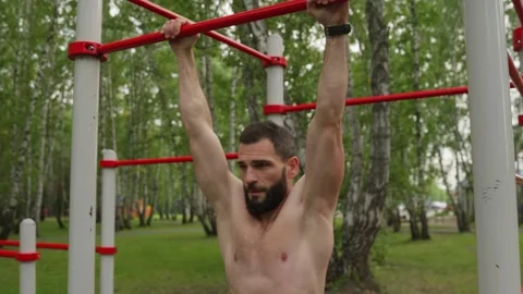 Strong Man Performs Hanging Leg Raises Outdoors Video stock 329599202