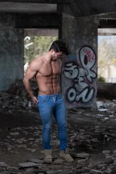 Strong Man Posing in Front of Graffiti Wall Stock-Fotos
