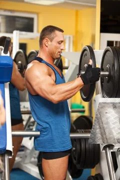 Strong man preparing his training machine Stock Photos