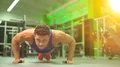 The strong man push up from the floor in the fitness center 4k or 4k+ Resolution