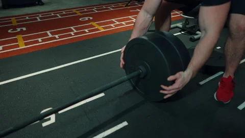 Strong man removing plates from barbell after workout Stock Footage 148323116