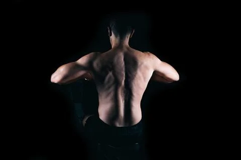 Strong man rowing on a machine. Stock Photos