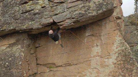 A strong man takes a difficult route on a steep cliff. Video stock 121918624