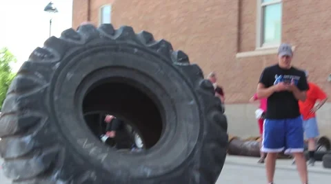 Strong Man Tire Push towards camera Stock Footage 68799182