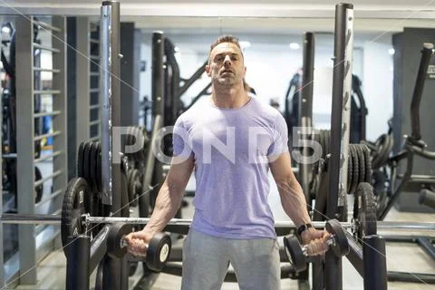 Strong man training in gym biceps top train. Stock Photos