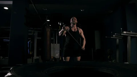 Strong man in training with a hammer and wheel Video stock 88930970