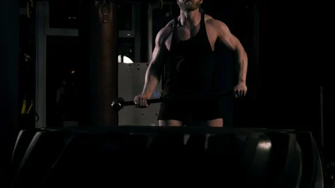 Strong man in training with a hammer and wheel Stock Footage 88931023