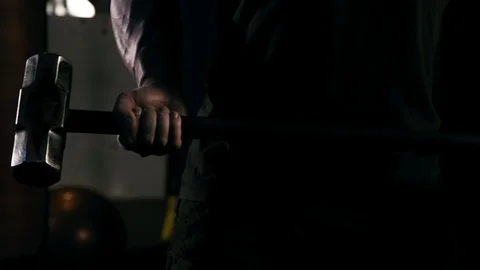 Strong man in training with a hammer and wheel Stock Footage 88931178