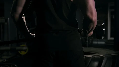 Strong man in training with a hammer and wheel Stock Footage 88931183