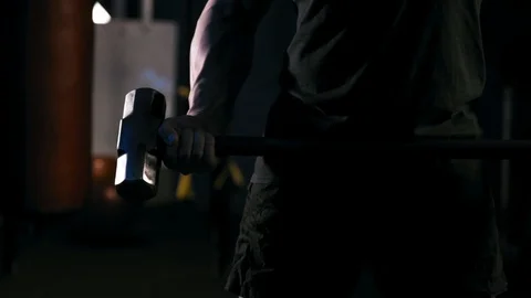 Strong man in training with a hammer and wheel Stock Footage 88931362